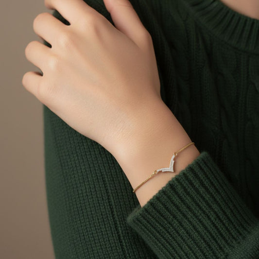 Abidii Vivid Bracelet – slim gold-tone bracelet with a V-shaped pavé center bar, styled by model, showing its modern, minimal sparkle.