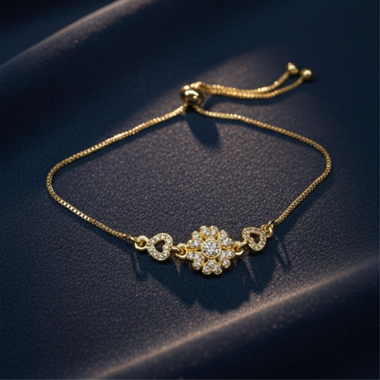 Abidii Affection Bracelet – slim gold-tone bracelet with a central flower motif and pavé hearts on each side, displayed on dark fabric, showing its delicate, romantic design.