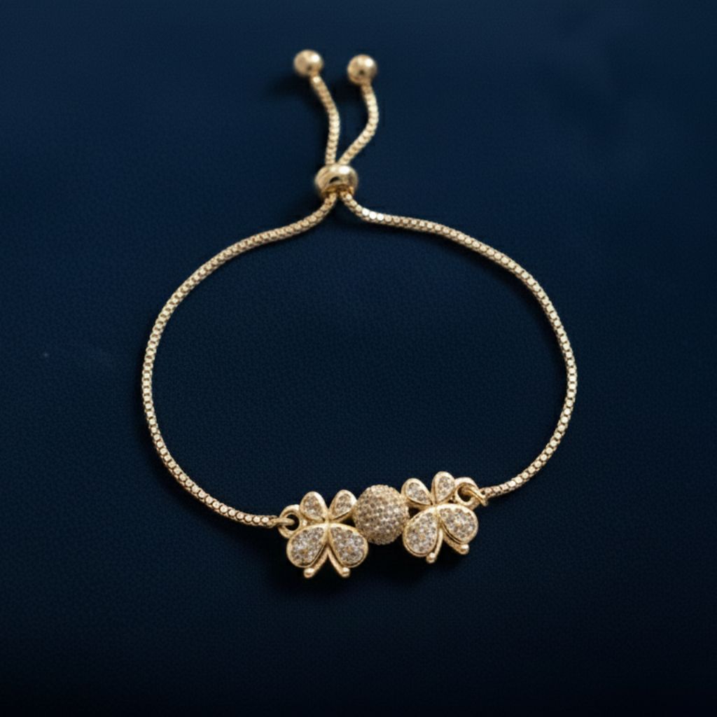 Abidii Angel Bracelet – slim gold-tone bracelet with two clover-like motifs and a pavé center bead, displayed on dark fabric, showing its delicate, winged design.