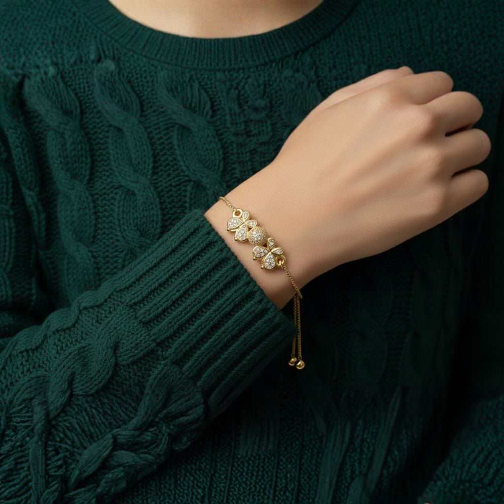 Abidii Angel Bracelet – slim gold-tone bracelet with two clover-like motifs and a pavé center bead, worn by model, showing its delicate, winged design.