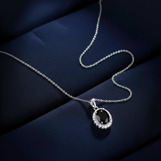 Abidii Eternity Set – oval halo pendant necklace with matching oval stud earrings displayed on a soft fabric surface, showing their timeless, luminous design.