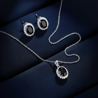 Abidii Eternity Set – oval halo pendant necklace with matching oval stud earrings displayed on a soft fabric surface, showing their timeless, luminous design.