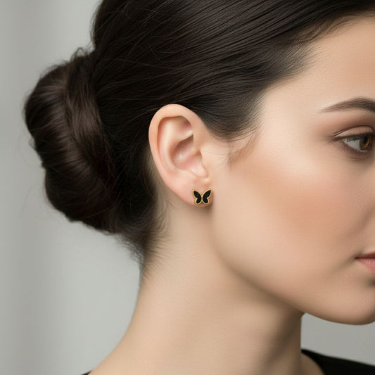 Abidii Flutter Studs – small butterfly outline stud earrings styled by a model, showing their delicate, minimal design.