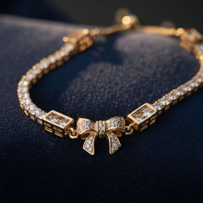 Abidii Loyalty Knot Bracelet – rose-gold-tone  bracelet with pavé bow centre and slider closure, displayed on dark fabric in soft light.