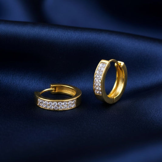 Abidii Nova Hoops – gold-tone pavé hoop earrings resting on a fabric, showing their minimal design and sparkling front.