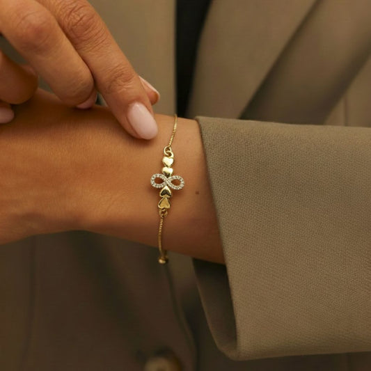 Abidii Promise Link Bracelet – slim gold-tone bracelet with pavé infinity symbol and linked accents, styled on a model, showing its delicate, adjustable design.