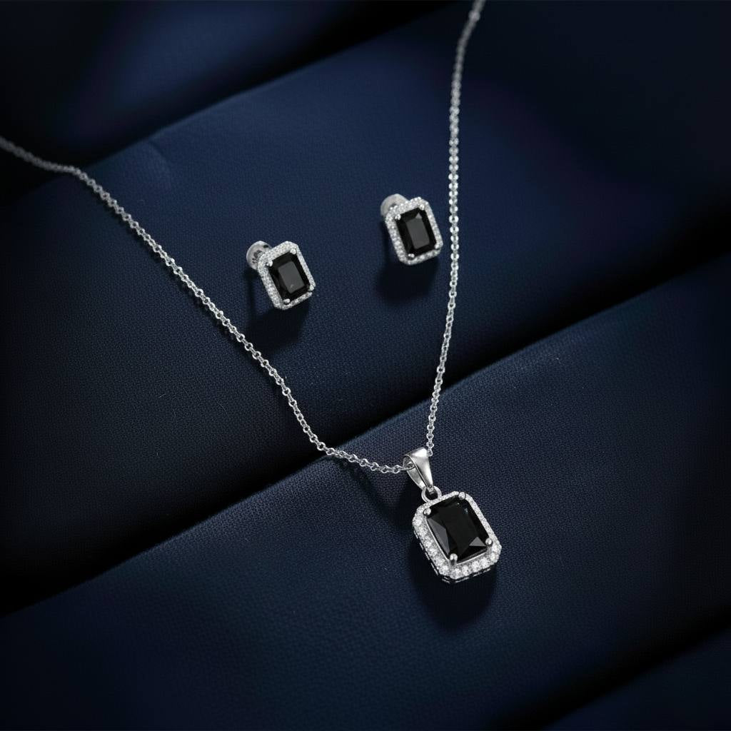Abidii Regalia Set – halo pendant necklace with matching stud earrings displayed on a soft fabric surface, showing their refined, delicate sparkle.