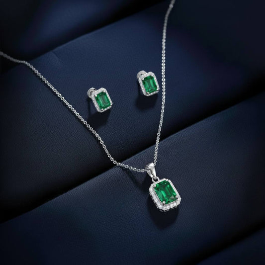 Abidii Regalia Set – halo pendant necklace with matching stud earrings displayed on a soft fabric surface, showing their refined, delicate sparkle.