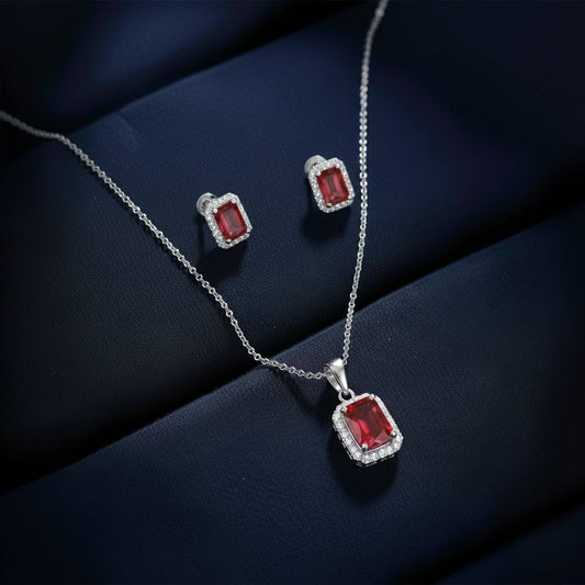 Abidii Regalia Set – halo pendant necklace with matching stud earrings displayed on a soft fabric surface, showing their refined, delicate sparkle.