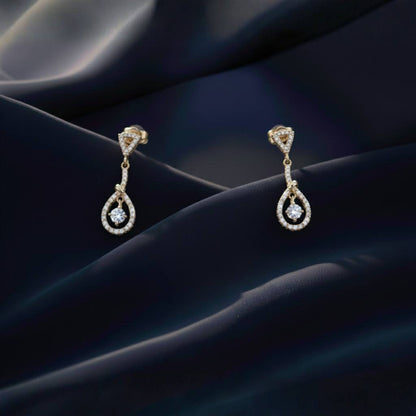 Abidii Zenith Set – teardrop halo pendant necklace with matching drop earrings displayed on dark, folded fabric, showing their luminous stones and elegant, elongated design.