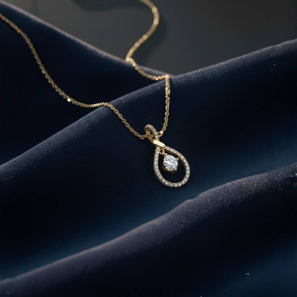 Abidii Zenith Set – teardrop halo pendant necklace with matching drop earrings displayed on dark, folded fabric, showing their luminous stones and elegant, elongated design.